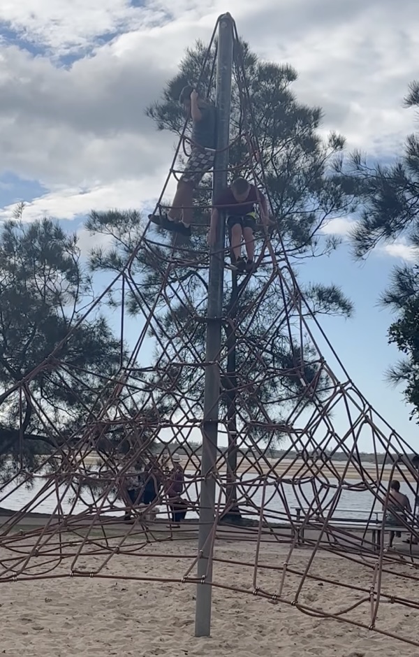 Boys climbing to the top of a playground tower at Cotton Tree park, Sunshine Coast