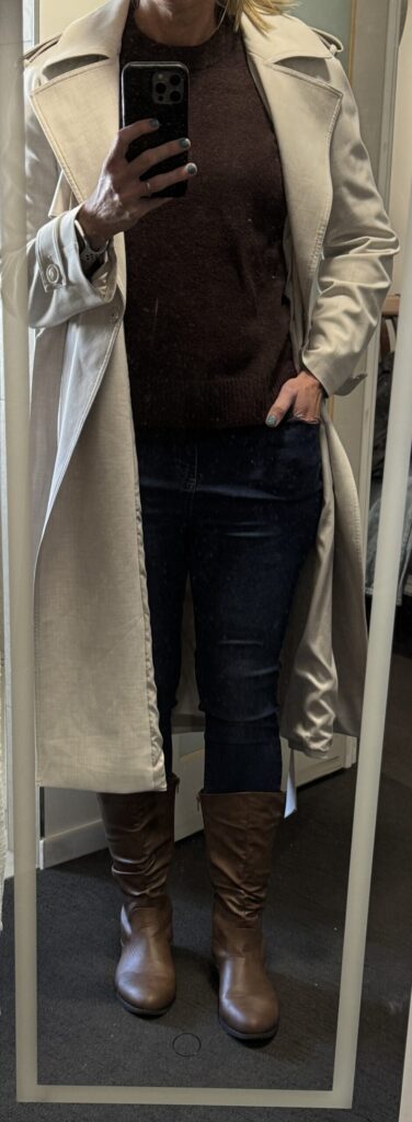 Outfit consisting of white trench coat, brown sweater, jeans, brown boots.