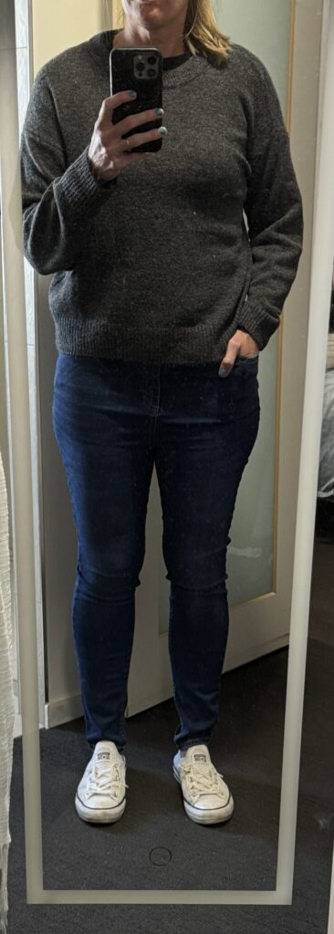 Outfit consisting of charcoal sweater, jeans, white shoes