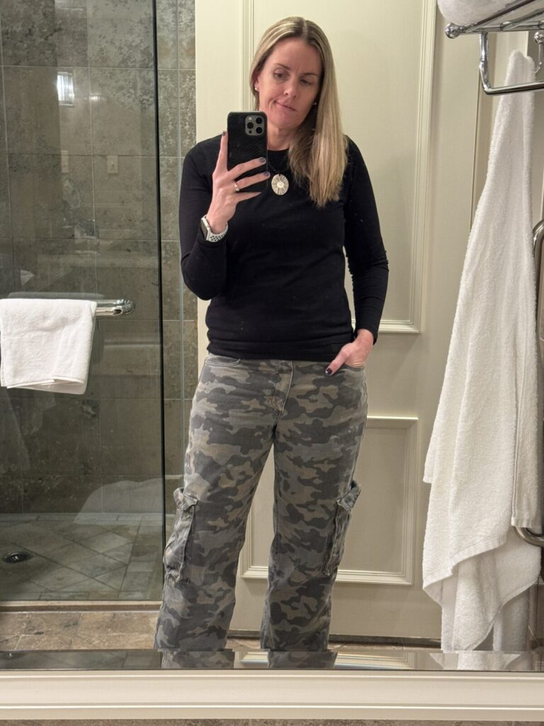 Outfit consisting of camo pants, black shirt.