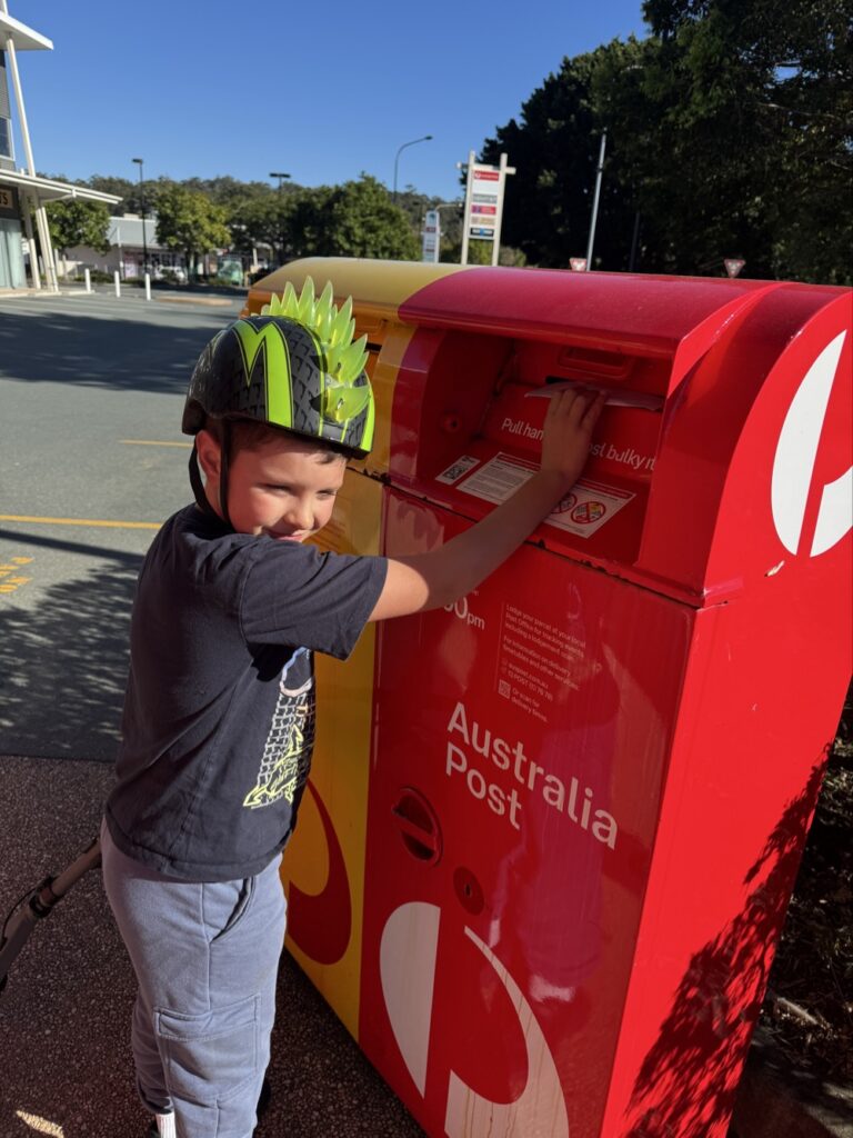 Sealed envelope going through the slot of a mailbox as part of a handwritten letter pen pal exchange